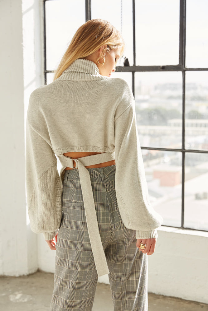 The back of this sweater has an adjustable belt tie detail.