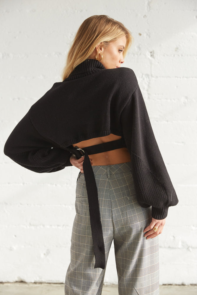 The back of this sweater is open with a belted design.