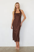 Woman wearing a brown satin dress against a white background