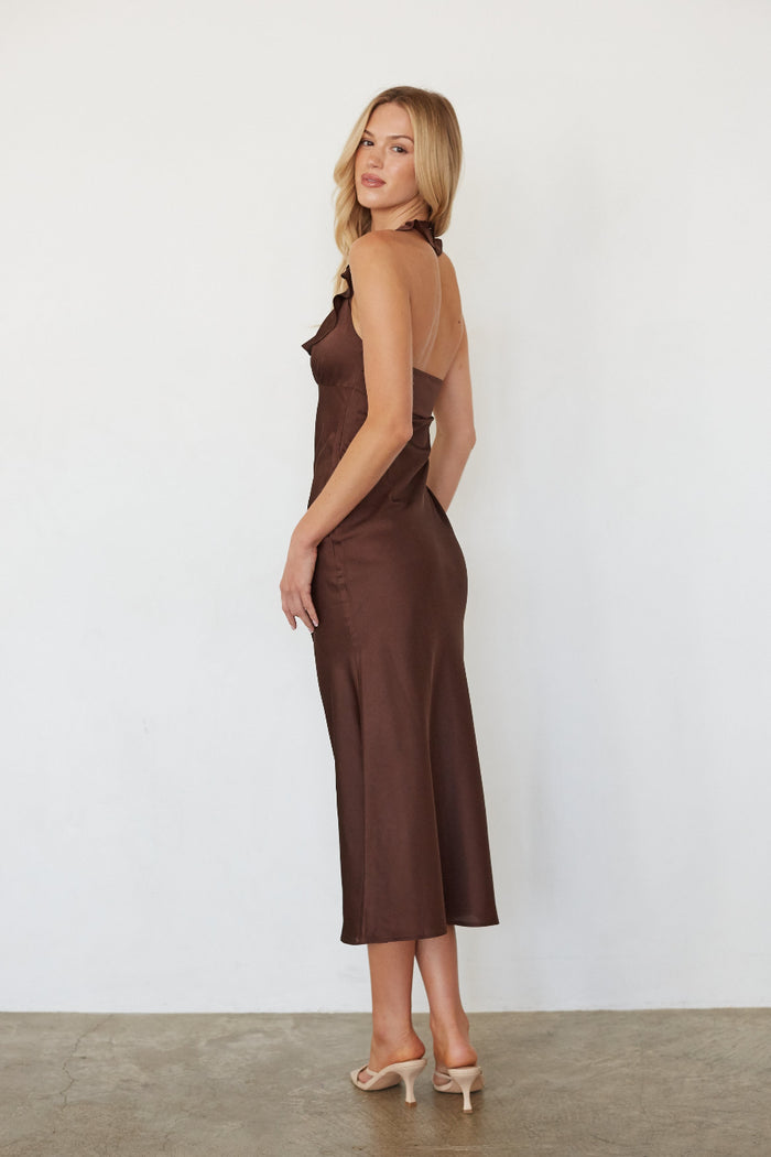 Woman wearing a brown dress against a white background