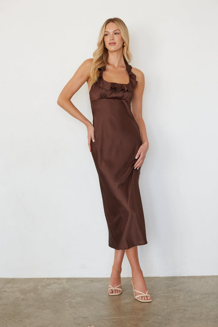 Woman wearing a brown dress against a white background