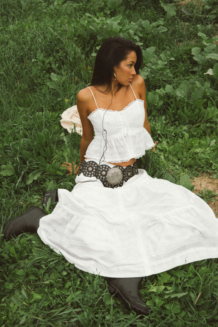 white-image | sitting-image | peplum white top | sitting pose showcasing the peplum white top with ruffled details, perfect for a laid-back look.