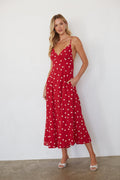 Woman wearing a red polka dot dress against a white background