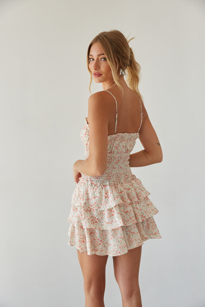 back view | pink floral romper with keyhole cutout, smocked waist, and tiered ruffle skirt