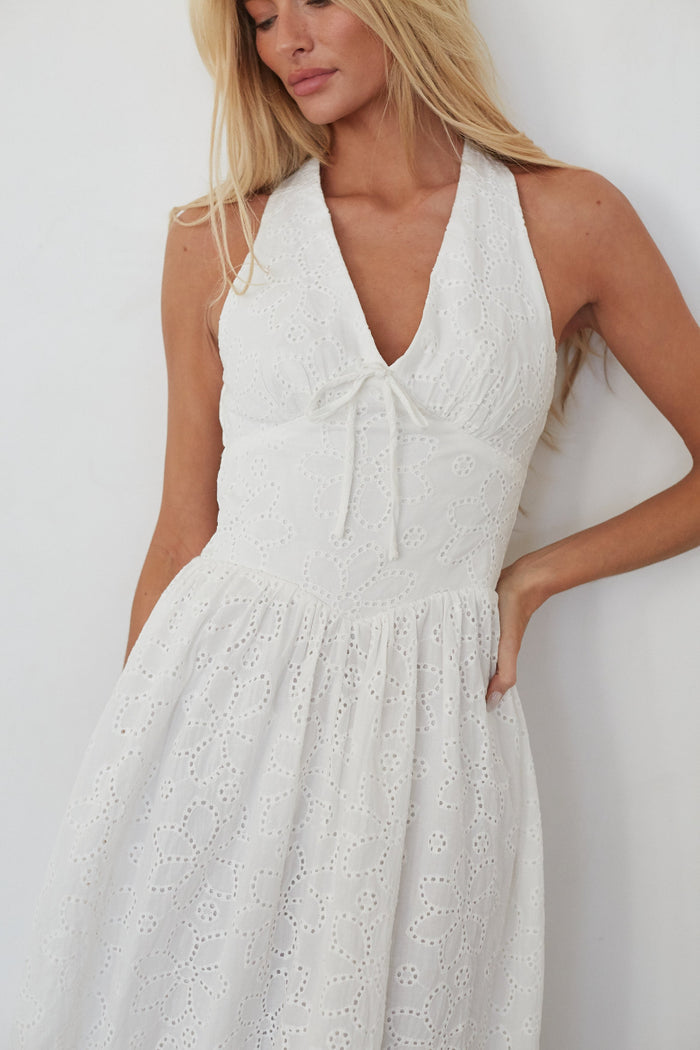 Woman wearing a white dress against a plain background