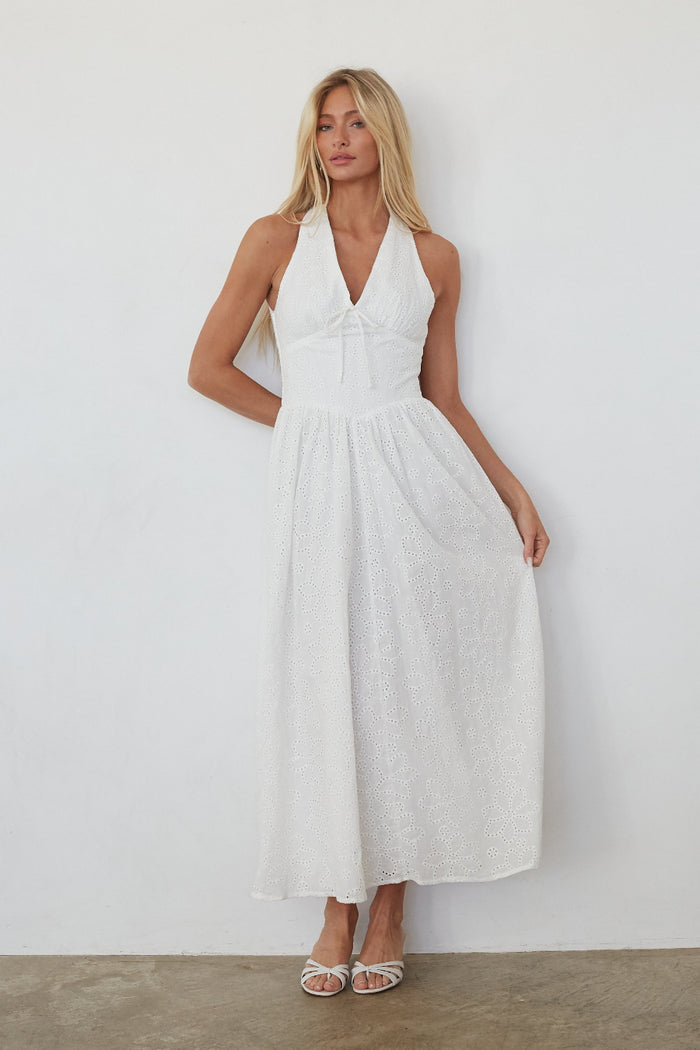 Woman wearing a white dress against a plain background