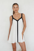 white-image | Woman wearing a white dress with black accents on a plain background
