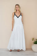 white-image | Woman wearing a white dress with black straps against a beige background