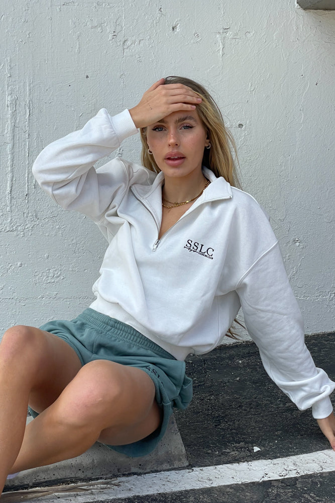 White zip up sweatshirt with stand up collar.