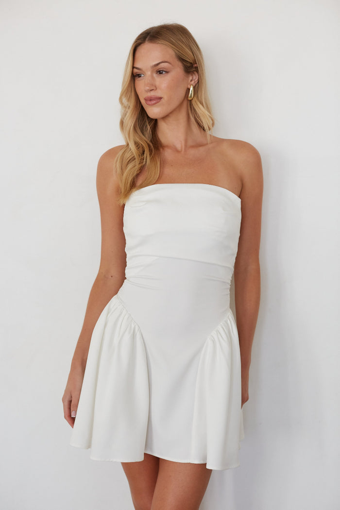 white-image | Woman wearing a white strapless dress against a plain background