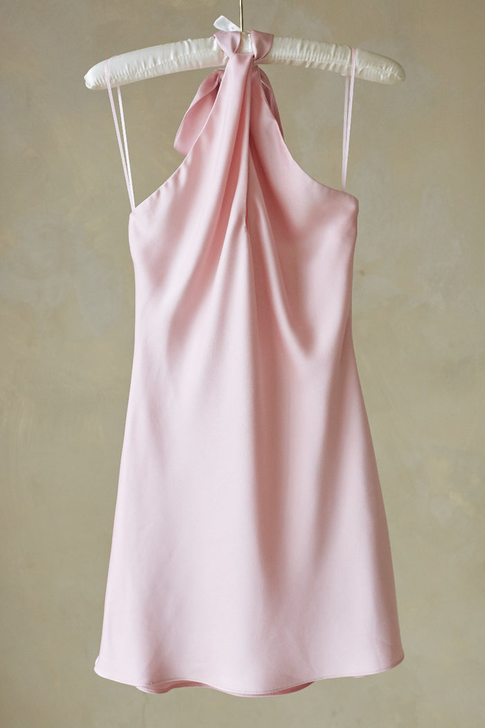 pink-image | Pink halter dress on a hanger against a beige background