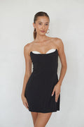 black-image | Woman wearing a black strapless dress against a white background
