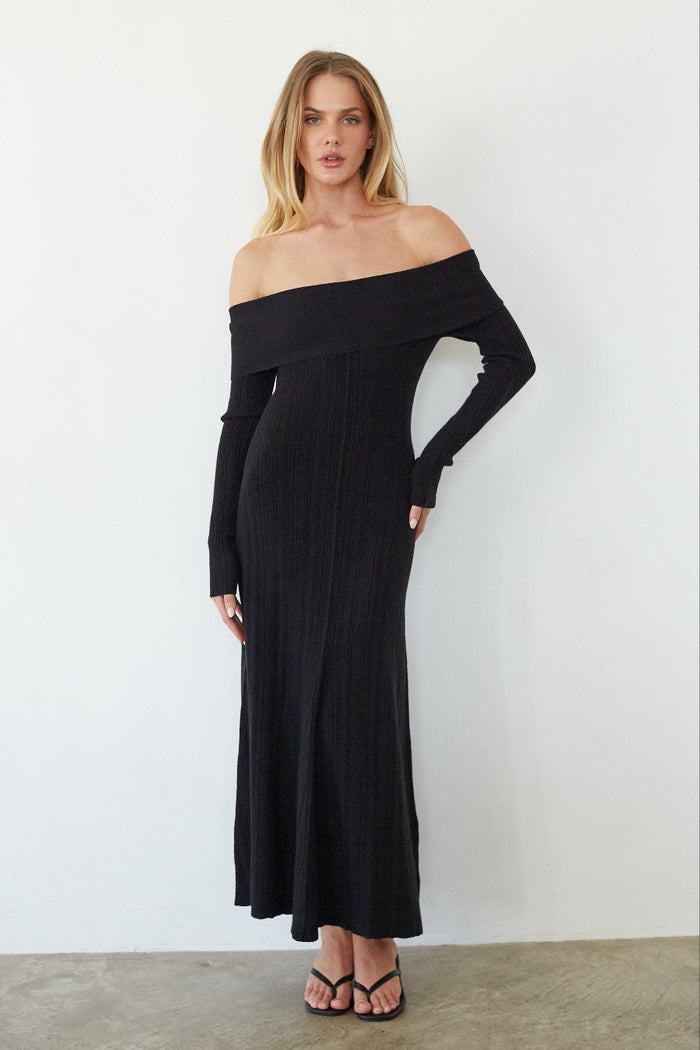 black-image| Woman wearing a black off-shoulder dress against a white background