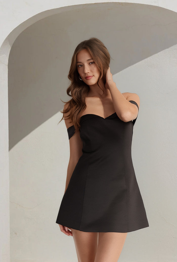 black-image | Woman wearing a black dress against a neutral background