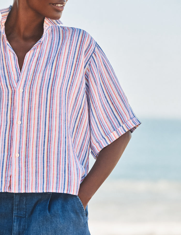 Person wearing a striped shirt with a blurred beach background