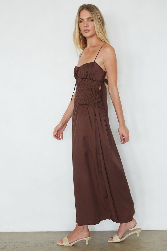 Woman wearing a brown dress against a white background