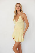 Woman wearing a yellow dress against a white background