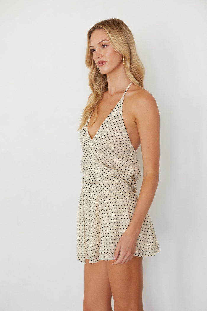 Woman wearing a polka dot dress against a white background