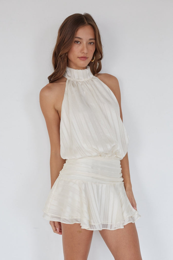 white-image | Woman wearing a white halter neck dress against a plain background