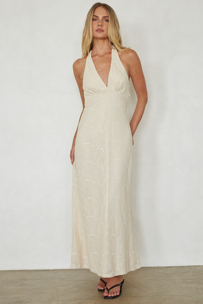 Woman wearing a long beige dress against a white background