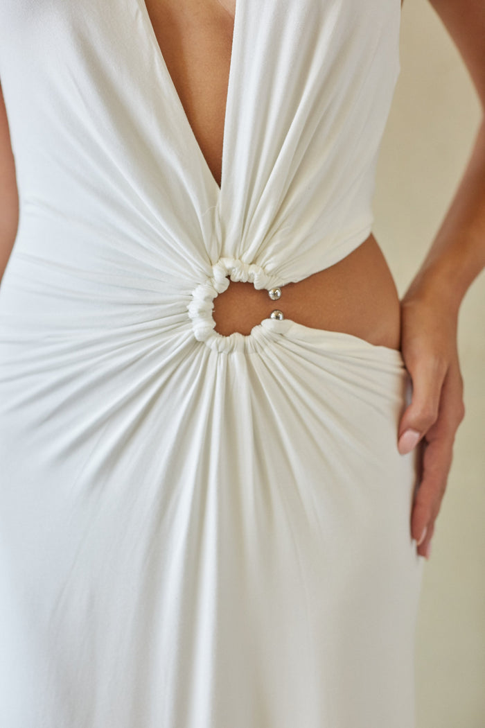Close-up of a white dress with a deep neckline and cut-out back.