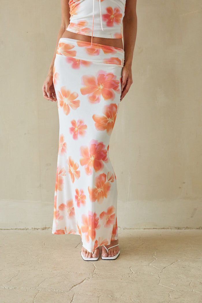 Person wearing a floral dress with a plain background