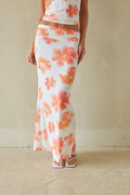 Person wearing a floral dress with a plain background