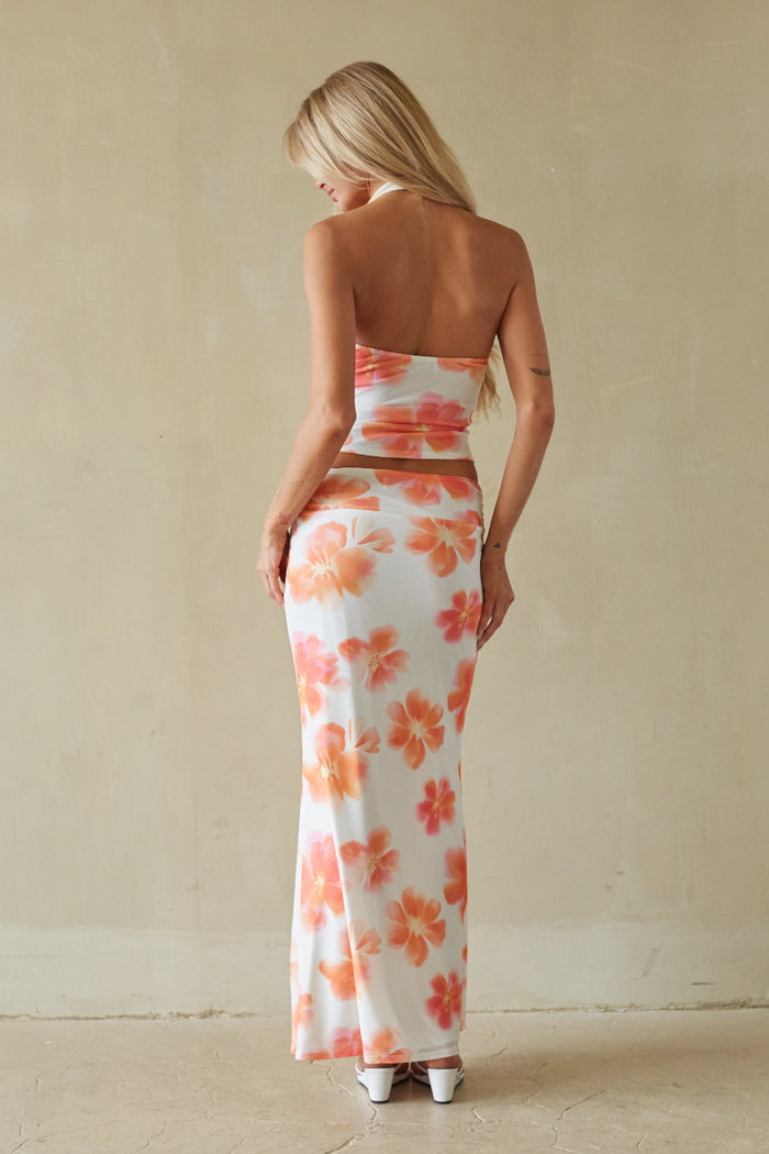 Woman wearing a strapless floral dress with a neutral background