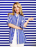 Woman wearing a blue and white striped shirt against a blue and white striped background