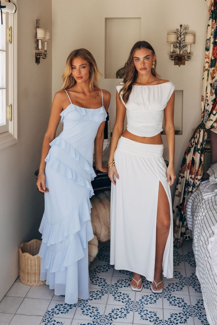 Two women in stylish outfits standing in a room with decorative elements.