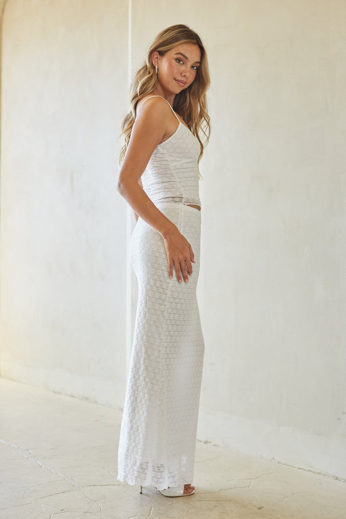 Woman wearing a white dress against a plain background