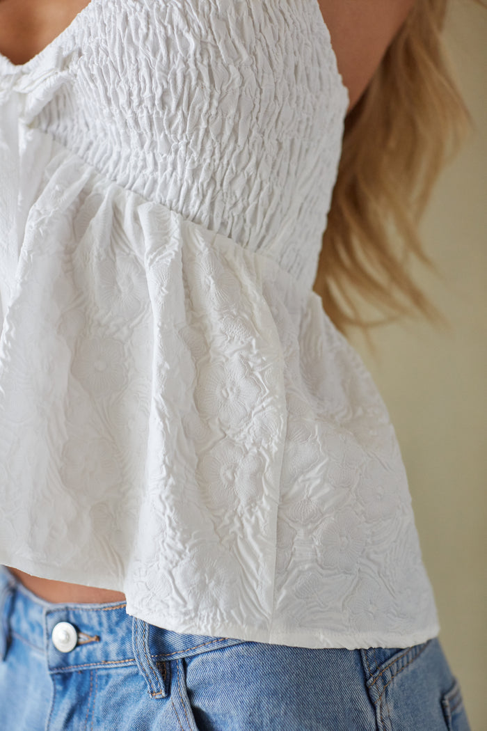 White textured blouse worn by a person with a blurred background