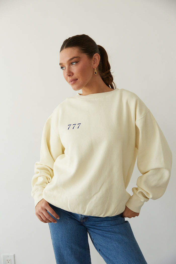 front view | butter yellow cozy crewneck that says The Lucky Club in Cobalt Blue with 777 Pocket detail