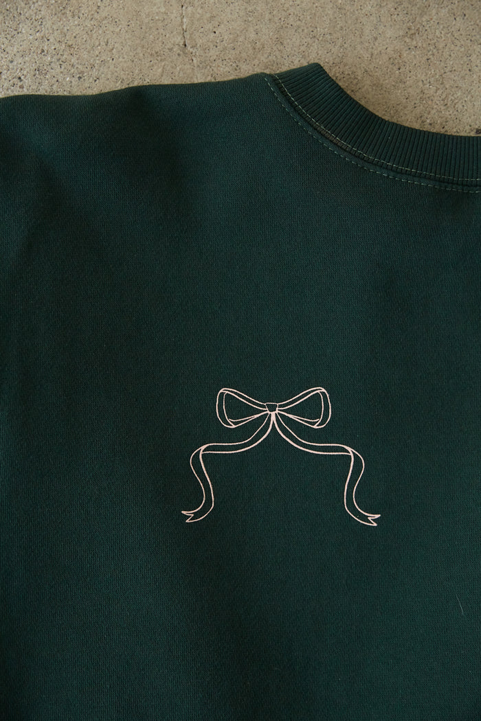 detail shot | forrest cozy crewneck that says The Sweetheart Department in Peach Pink with Bow Pocket detail