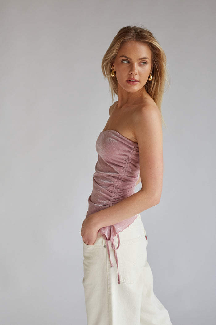shimmery pink tube top with side cinch and asymmetrical hem and bow | barbiecore outfit boutique