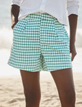 Person wearing green checkered shorts on a beach
