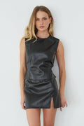 Woman wearing a black leather dress against a white background