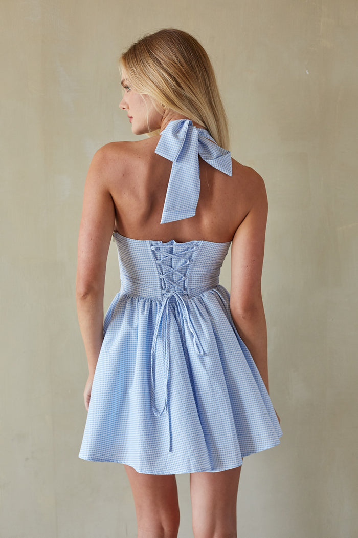 Back-image | Gingham Mini Dress | back view emphasizing the halter straps and the simple, smooth design of the dress.