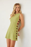 Woman wearing a green dress with buttons on a white background